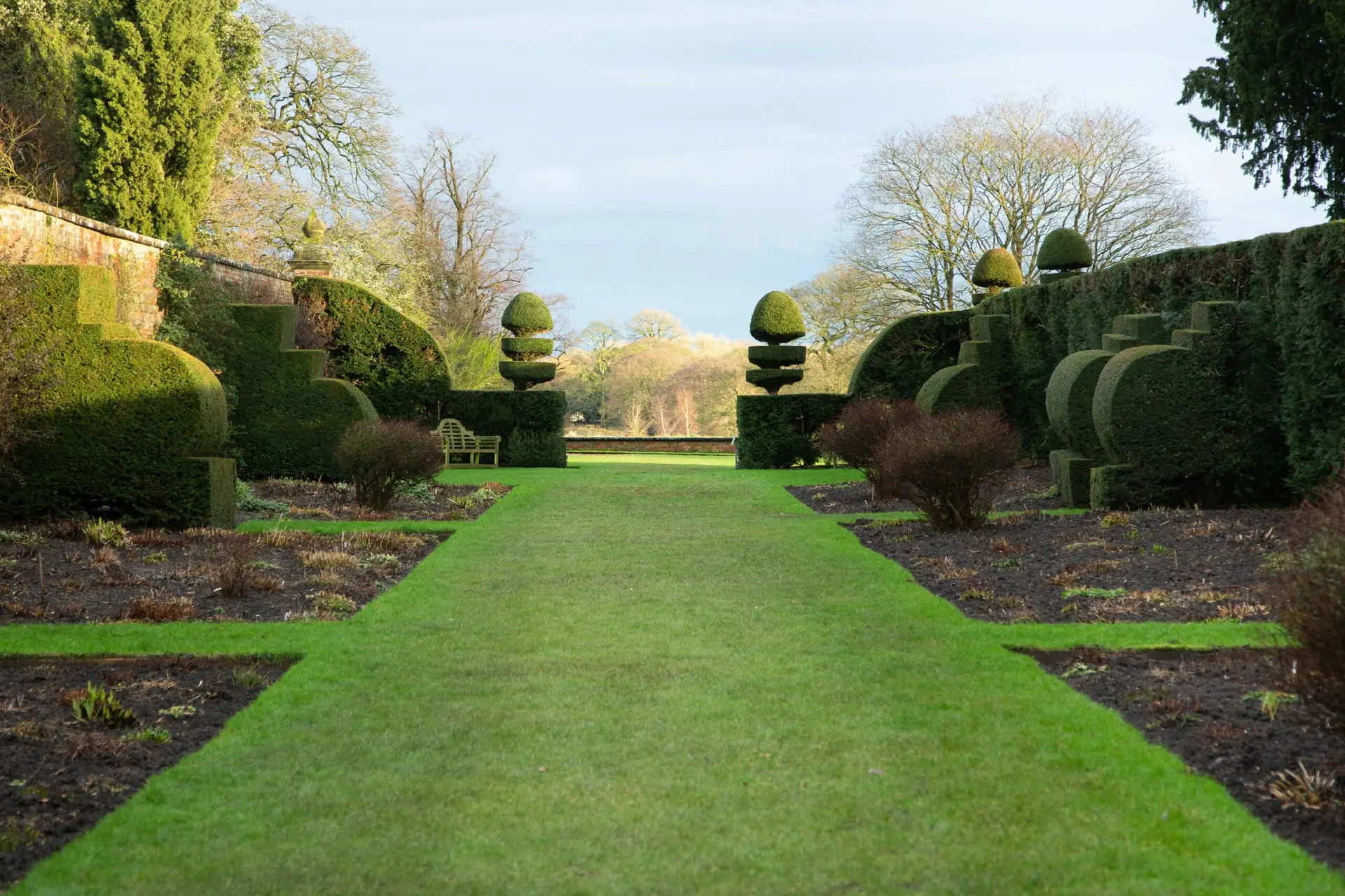 Jardin paysager structuré avec topiaires et pelouse impeccable